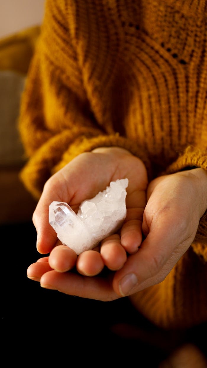 about-01 Close-up of hands holding a healing quartz crystal, representing alternative therapy and energy healing.