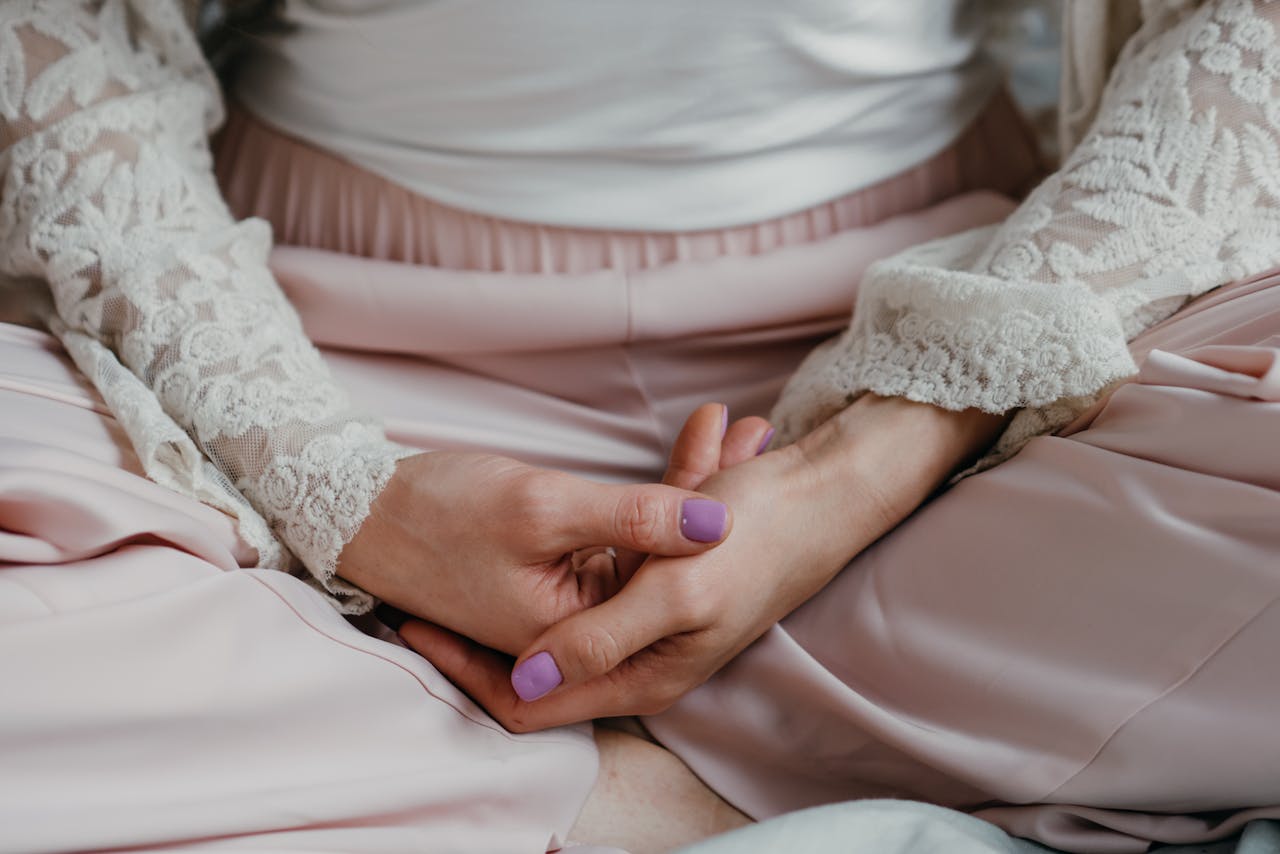 A woman in elegant lace attire practicing meditation in a calm indoor setting.