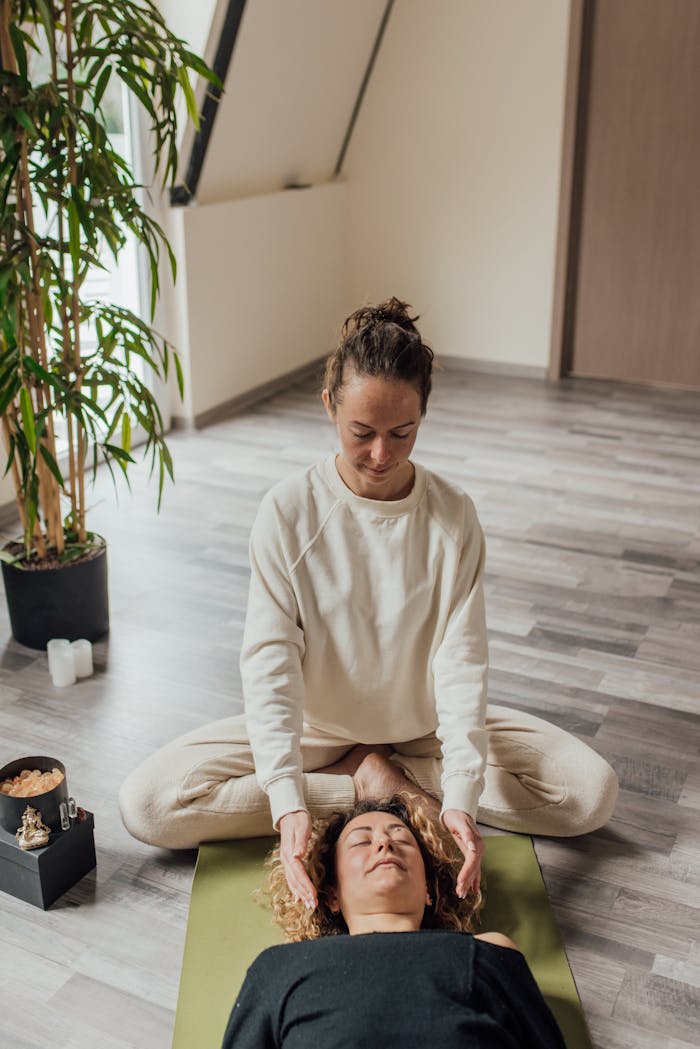 services-02 A serene Reiki healing session with a practitioner and client in a tranquil indoor space.